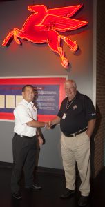 David Tsurusaki, strategic global alliance manager, ExxonMobil Fuels & Lubricants presents Museum Executive Director Wendell Strode with a neon Pegasus